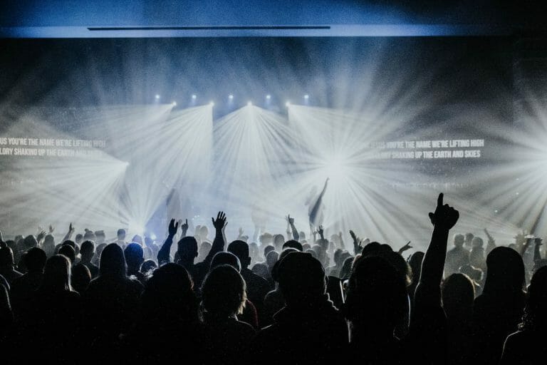 a group of people watching a band on stage in front of a crowd