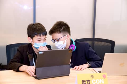 Two children looking at a laptop